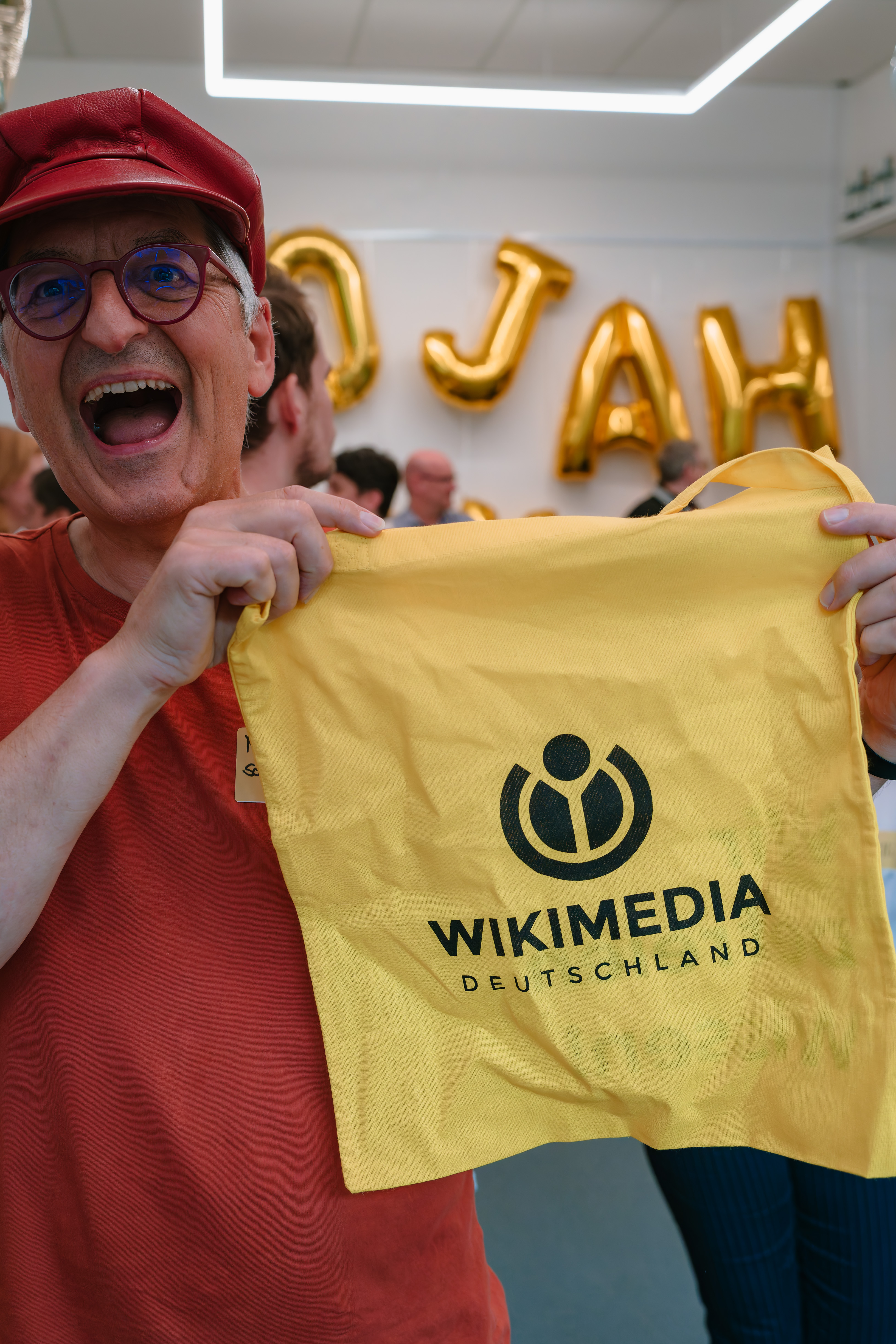 Und noch ein Quiz: Über einen QR-Code gelangten die Gäste und Mitglieder zu einem Quiz, in dem sie ihr Wissen über die 20-jährige Geschichte von Wikimedia Deutschland testen konnten. Hier freut sich Martin Schniewind über seinen Gewinn: einen der beliebten Wikimedia-Jutebeutel.