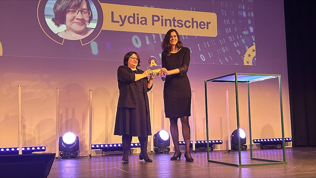 Lydia Pintscher wird der European Open Source Award auf einer Bühne überreicht.